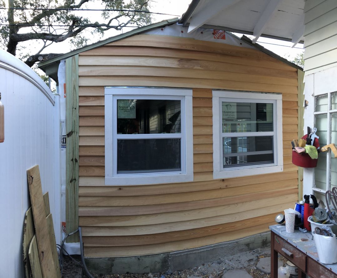 Finished small space exterior with new cedar siding and windows in Roser Park