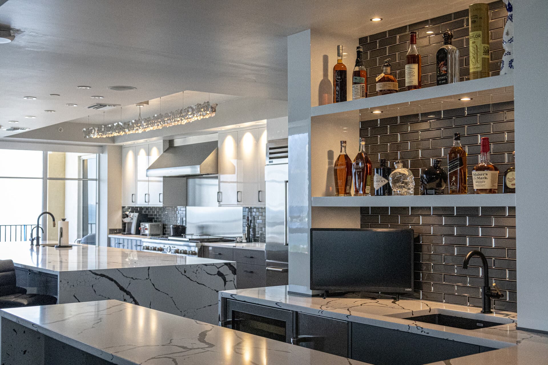 High-end condo with marble bar and dark subway tile
