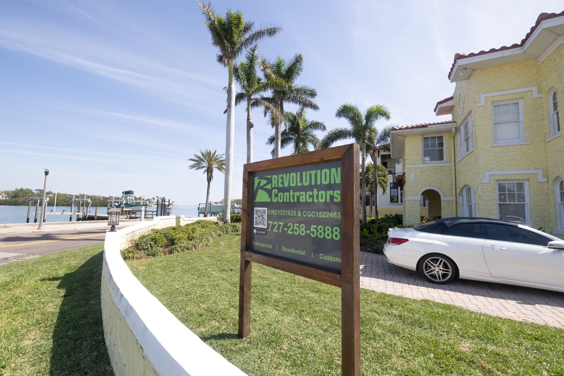 Revolution Contractors sign at waterfront property with palms in St. Petersburg