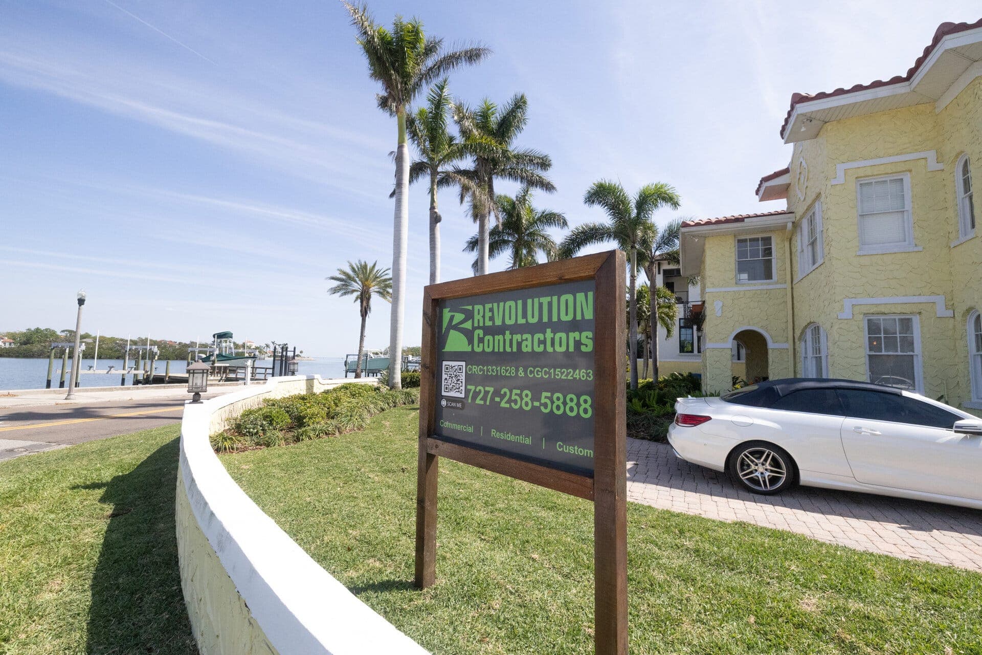 Revolution Contractors sign at waterfront property with palms in St. Petersburg