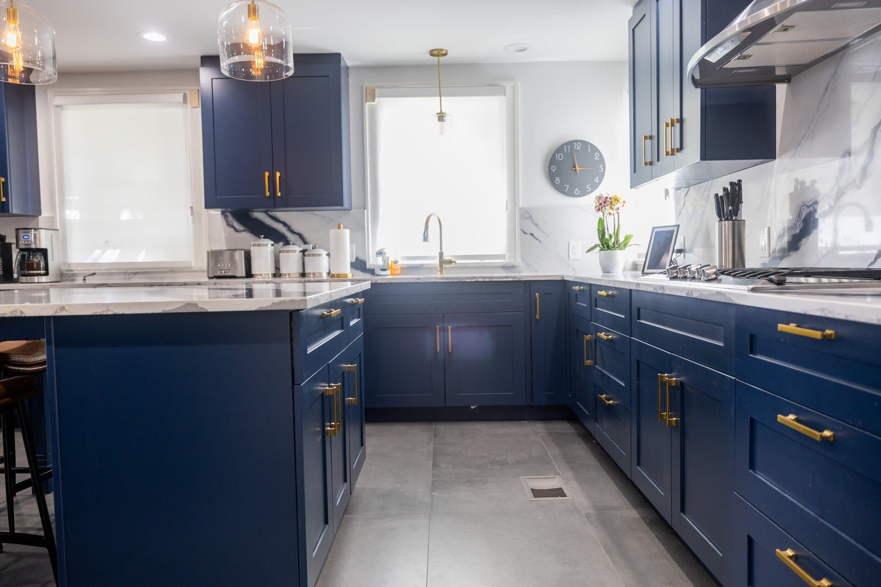 Navy blue cabinets with gold hardware and marble counters
