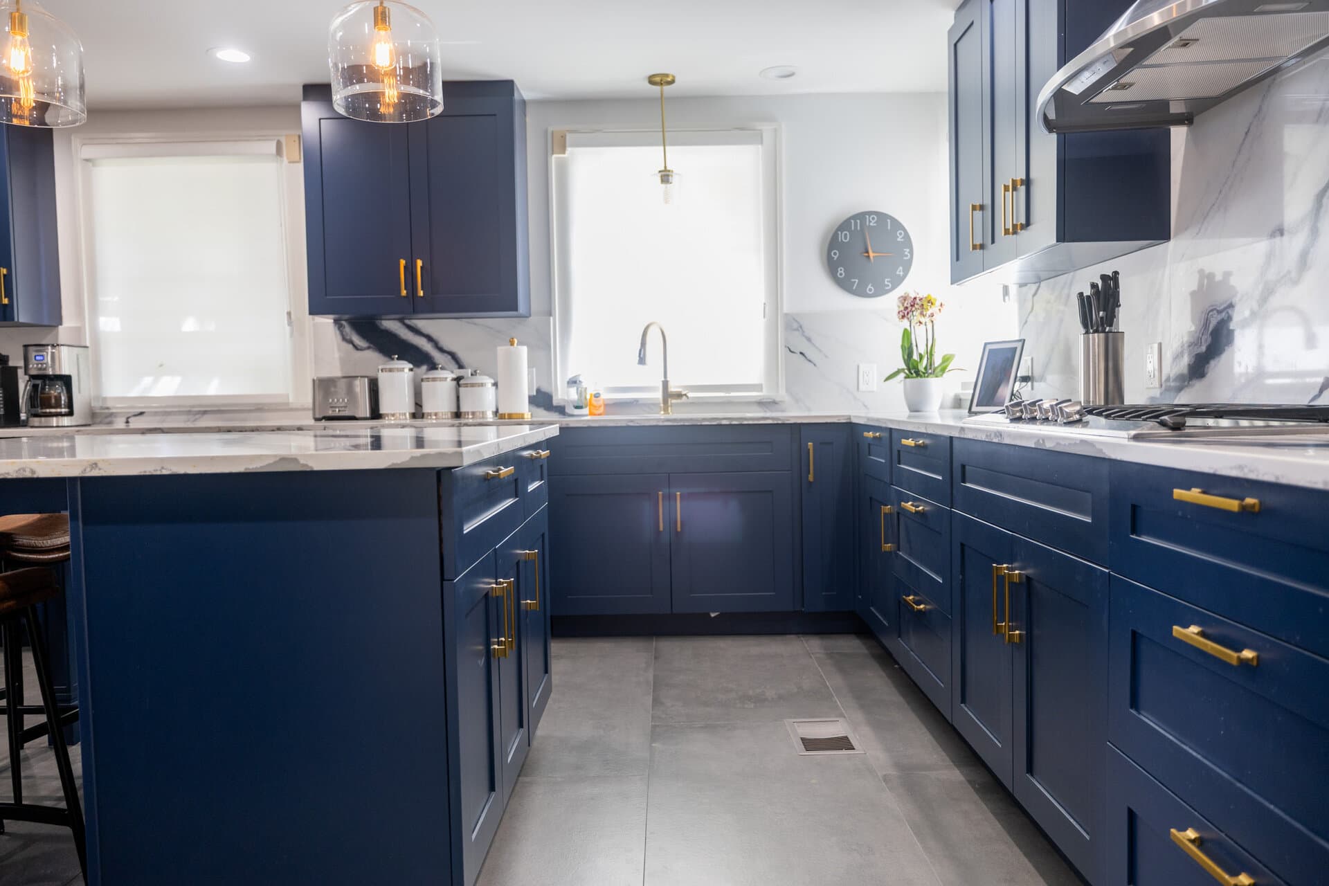 Navy blue cabinets with gold hardware and marble counters