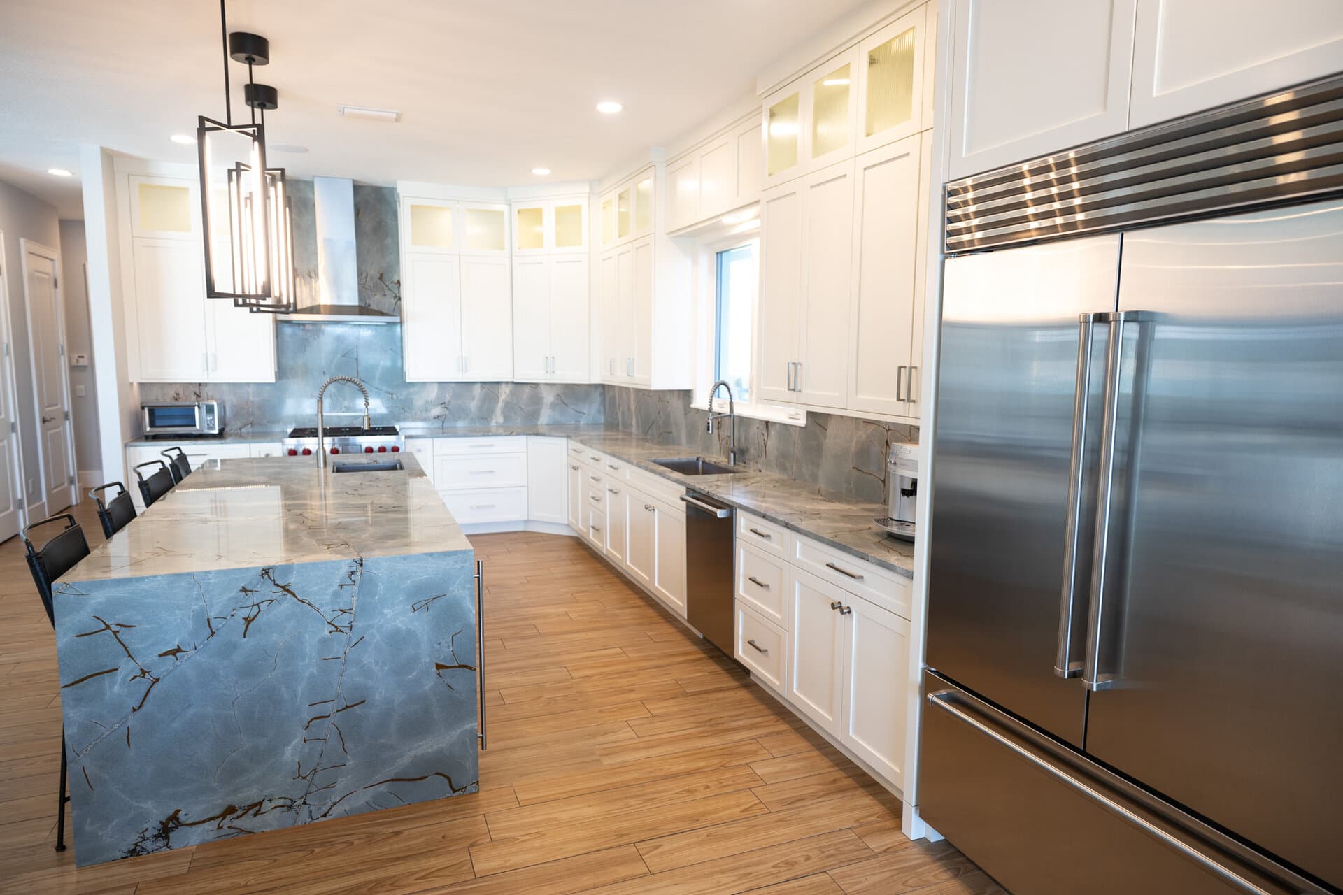 Blue marble waterfall island kitchen with white cabinets in St. Petersburg
